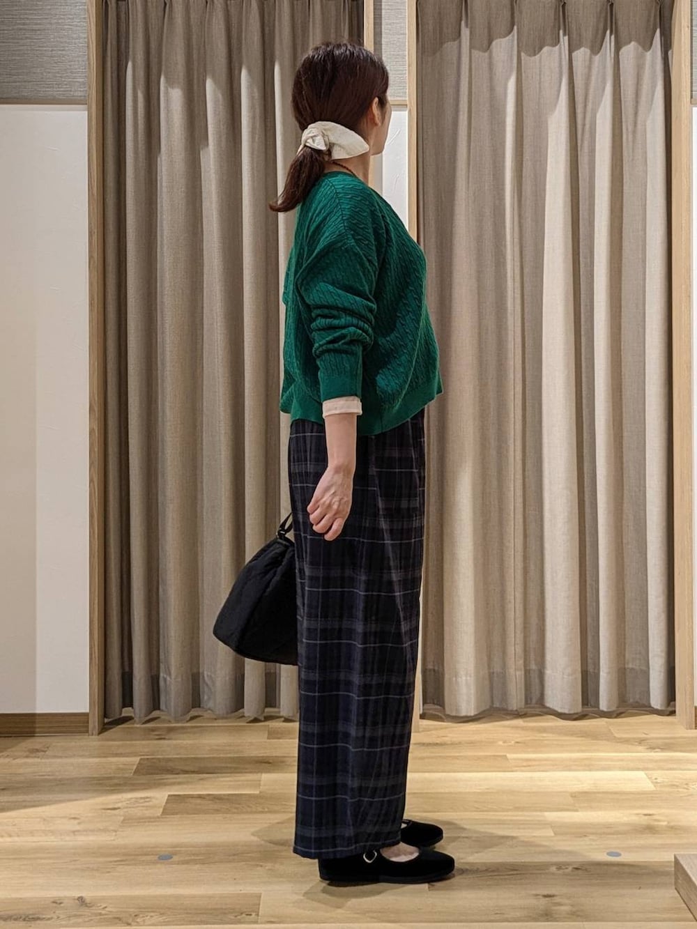 ブラック系のその他シューズ、グリーン系のカーディガン/ボレロ、ホワイト系のTシャツ/カットソーを着用したレディースの秋コーディネートの2枚目の写真