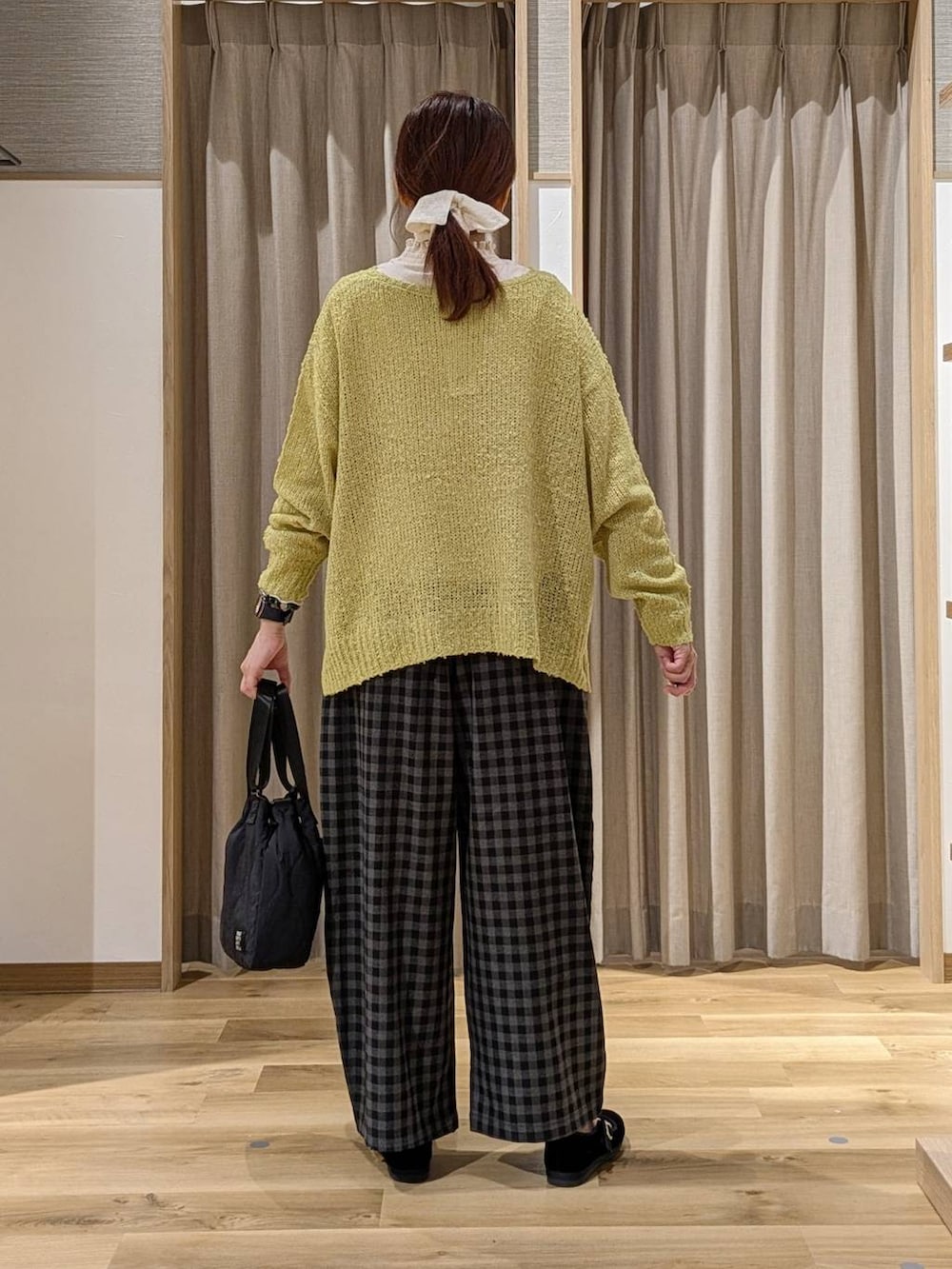 ブラック系のその他シューズ、グリーン系のニット/セーター、グレー系のその他パンツを着用したレディースの秋コーディネートの3枚目の写真