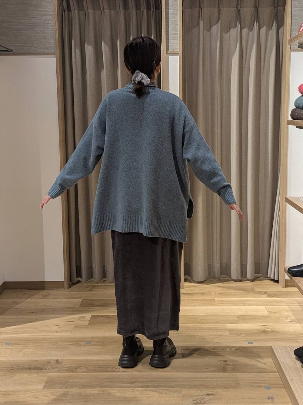 ブラック系のブーツ、グレー系のスカート、グリーン系のニット/セーターを着用したレディースの冬コーディネートの2枚目の写真