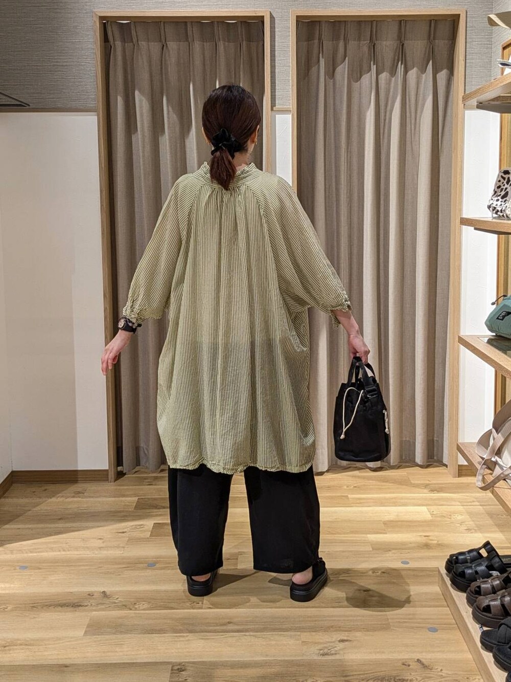 イエロー系のワンピース、ブラック系のサンダル、ブラック系のその他パンツを着用したレディースの夏コーディネートの2枚目の写真