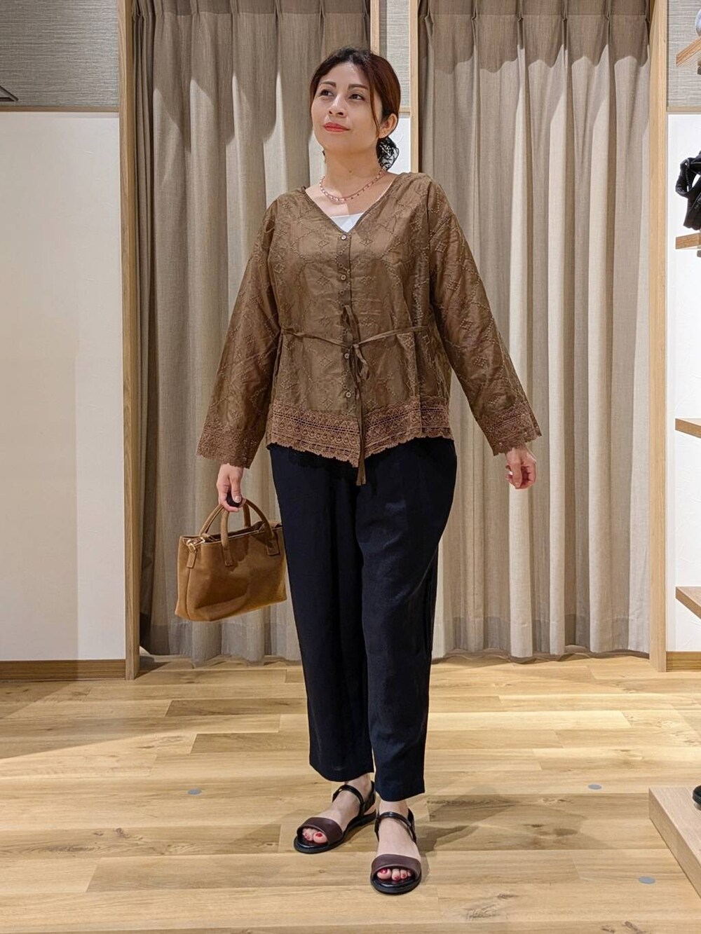 ブラウン系のショルダーバッグ、ブルー系のその他パンツ、ブラウン系のサンダルを着用したレディースの夏コーディネートの3枚目の写真
