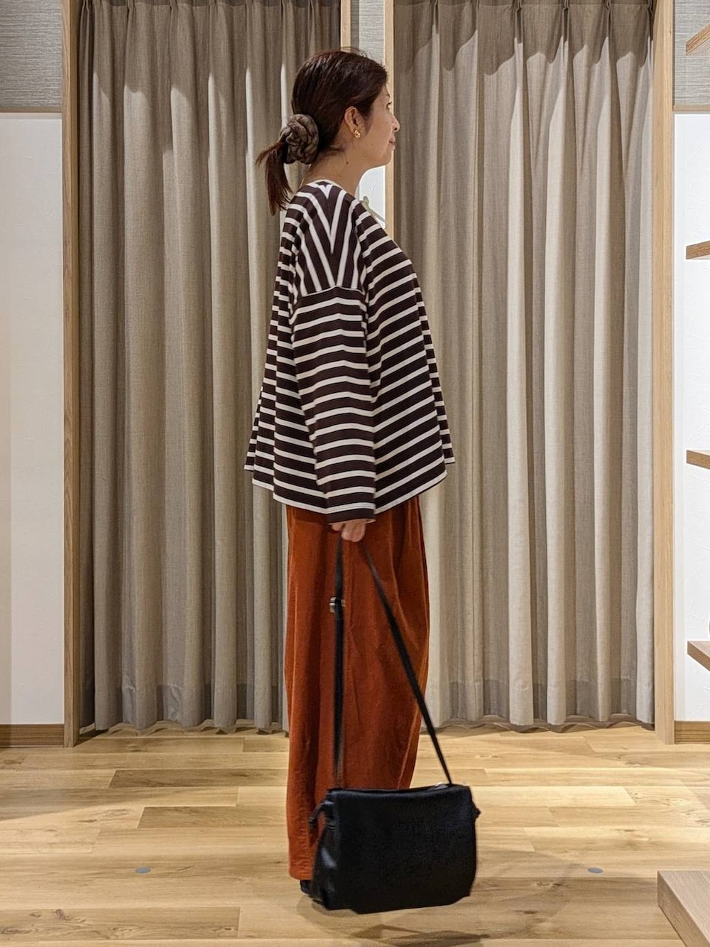 オレンジ系のその他パンツ、ブラック系のその他シューズ、ベージュ系のシャツ/ブラウスを着用したレディースの秋コーディネートの2枚目の写真