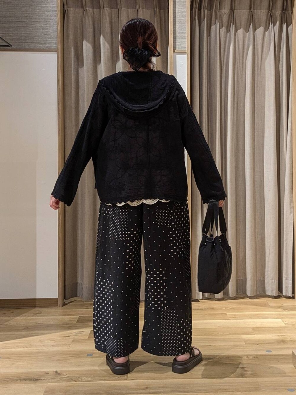 ベージュ系のベスト、ブラック系のシャツ/ブラウス、ブラウン系のサンダルを着用したレディースの夏コーディネートの3枚目の写真
