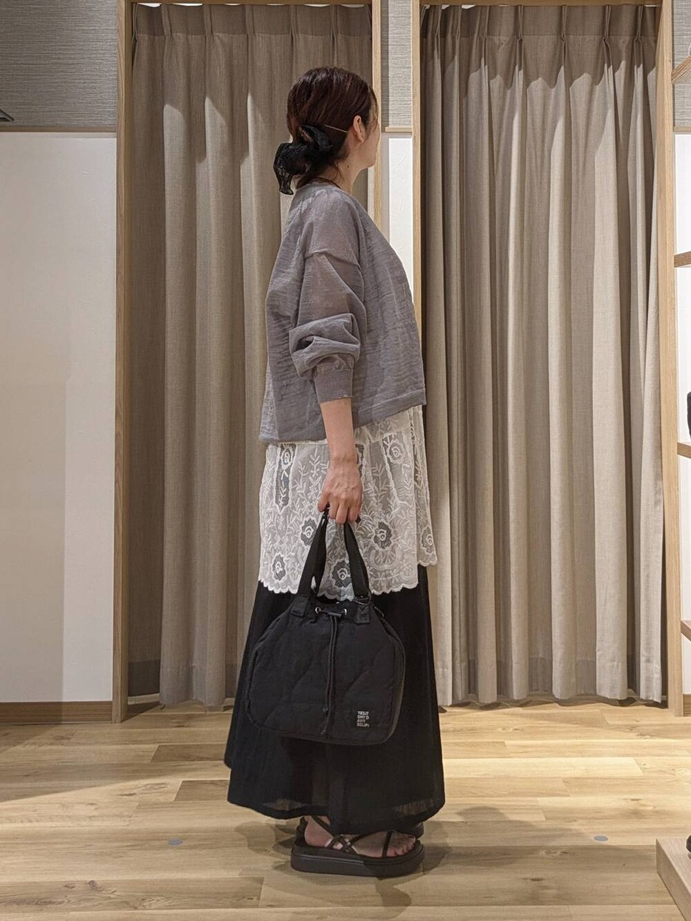 ブラック系のその他パンツ、ホワイト系のチュニック、ブラウン系のサンダルを着用したレディースの夏コーディネートの2枚目の写真