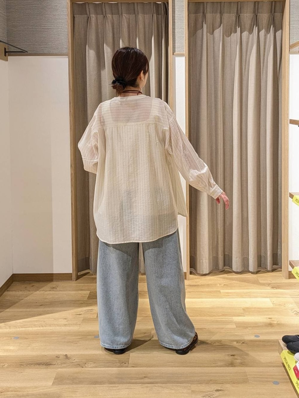 ブルー系のデニムパンツ、ベージュ系のタンクトップ、ブラウン系のパンプスを着用したレディースの春コーディネートの2枚目の写真