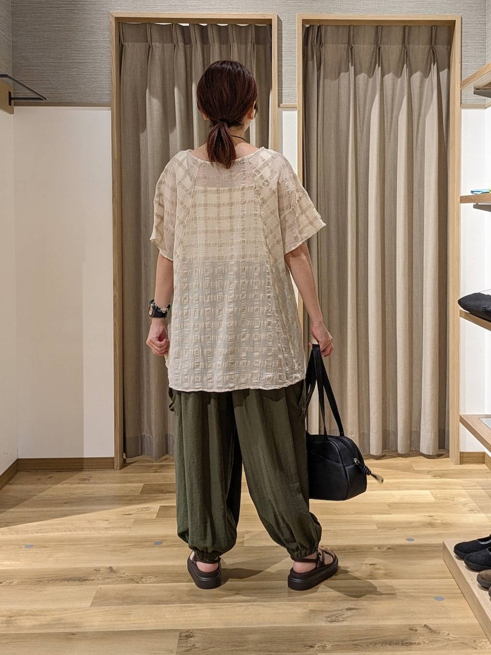 グリーン系のカーゴパンツ、ブラック系のショルダーバッグ、ブラウン系のサンダルを着用したレディースの夏コーディネートの2枚目の写真