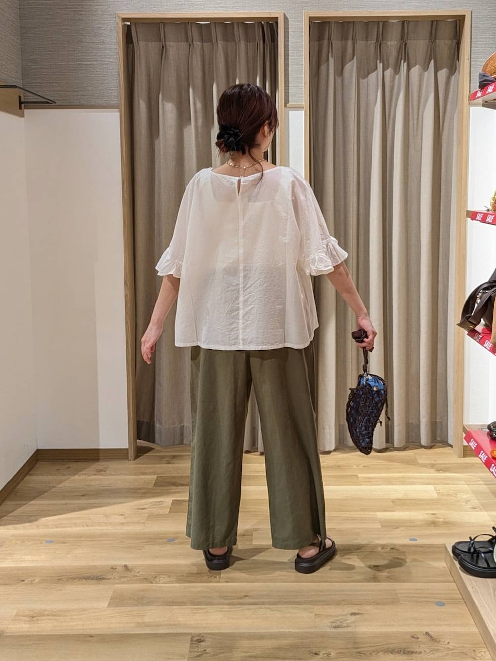 ブラウン系のショルダーバッグ、ブラウン系のサンダル、グリーン系のその他パンツを着用したレディースの夏コーディネートの2枚目の写真