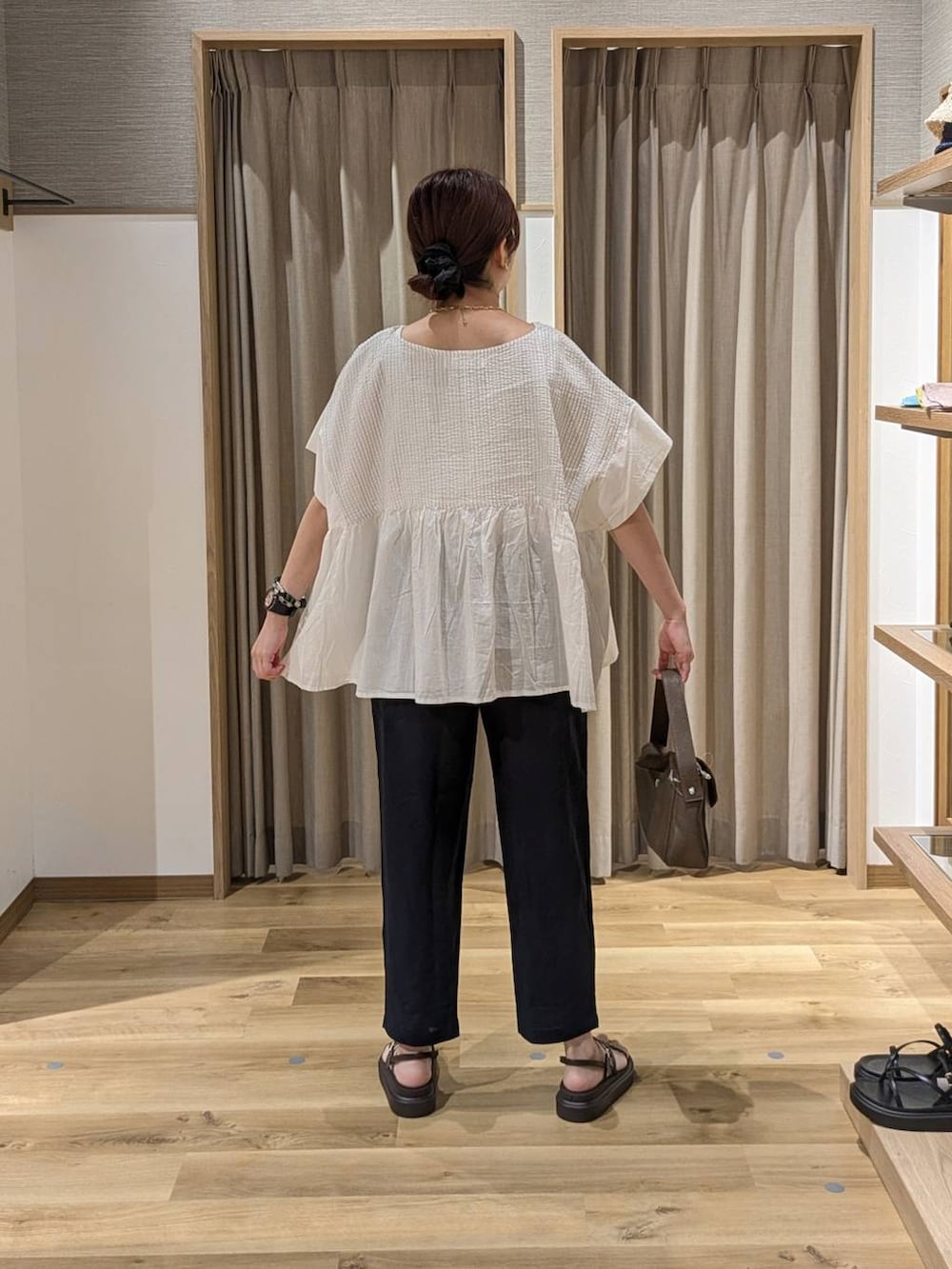 ブラウン系のサンダル、ブルー系のその他パンツ、ブラウン系のショルダーバッグを着用したレディースの夏コーディネートの2枚目の写真