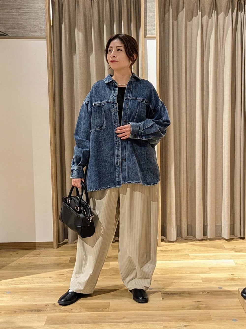 ブラック系のTシャツ/カットソー、ブルー系のシャツ/ブラウス、ブラック系のショルダーバッグを着用したレディースの冬コーディネートの2枚目の写真