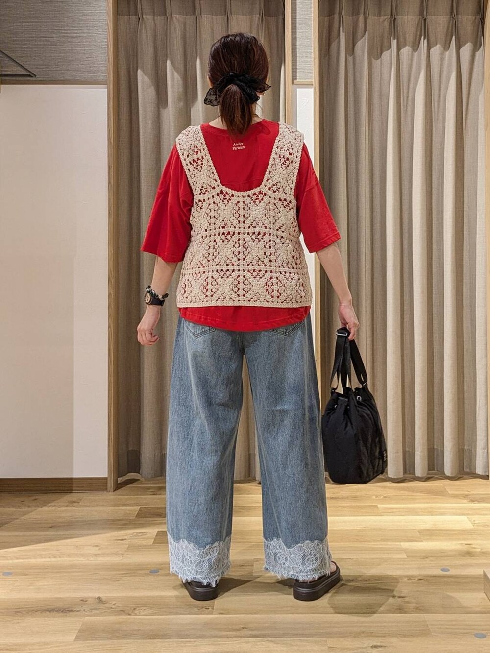 ブルー系のデニムパンツ、レッド系のTシャツ/カットソー、ベージュ系のベストを着用したレディースの夏コーディネートの3枚目の写真
