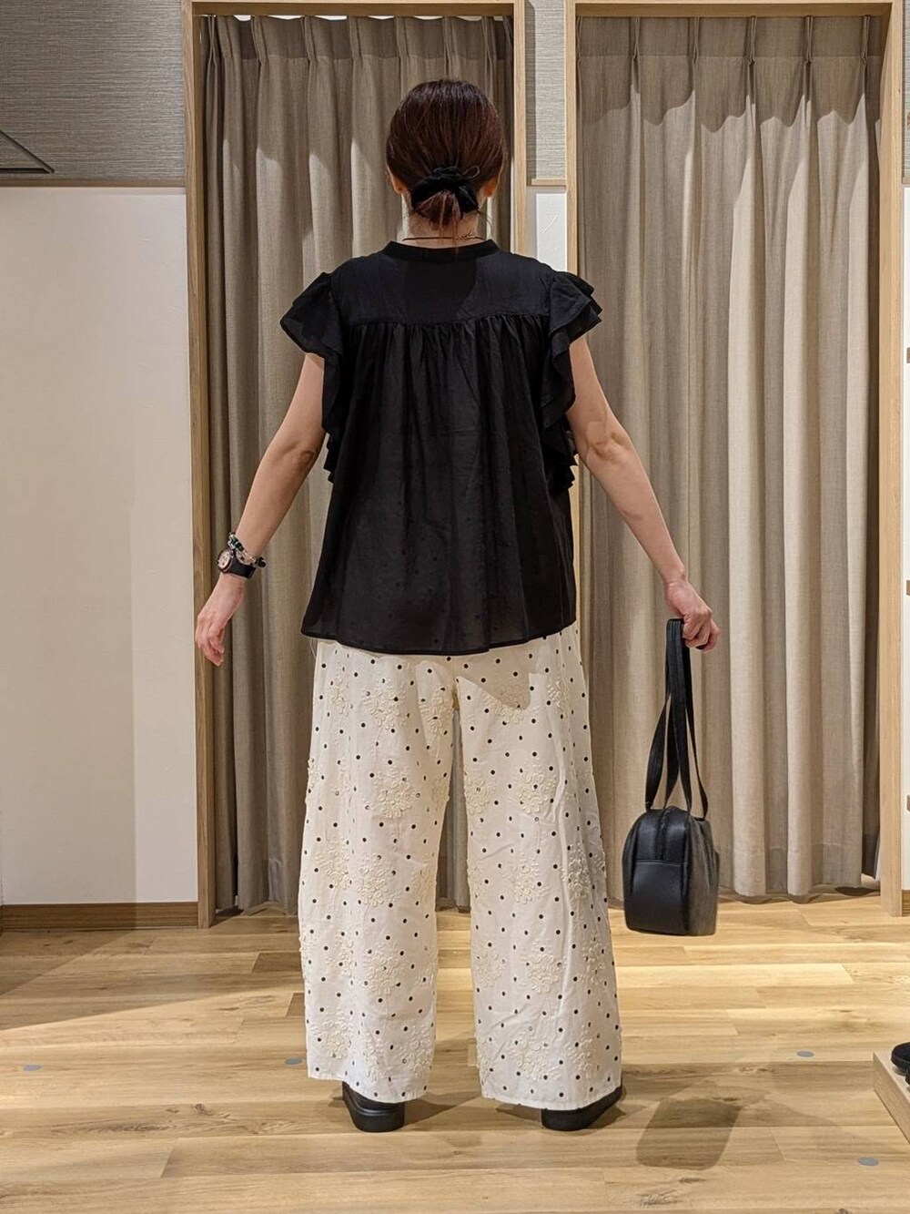 ブラック系のシャツ/ブラウス、ブラック系のショルダーバッグ、ホワイト系のその他パンツを着用したレディースの夏コーディネートの3枚目の写真