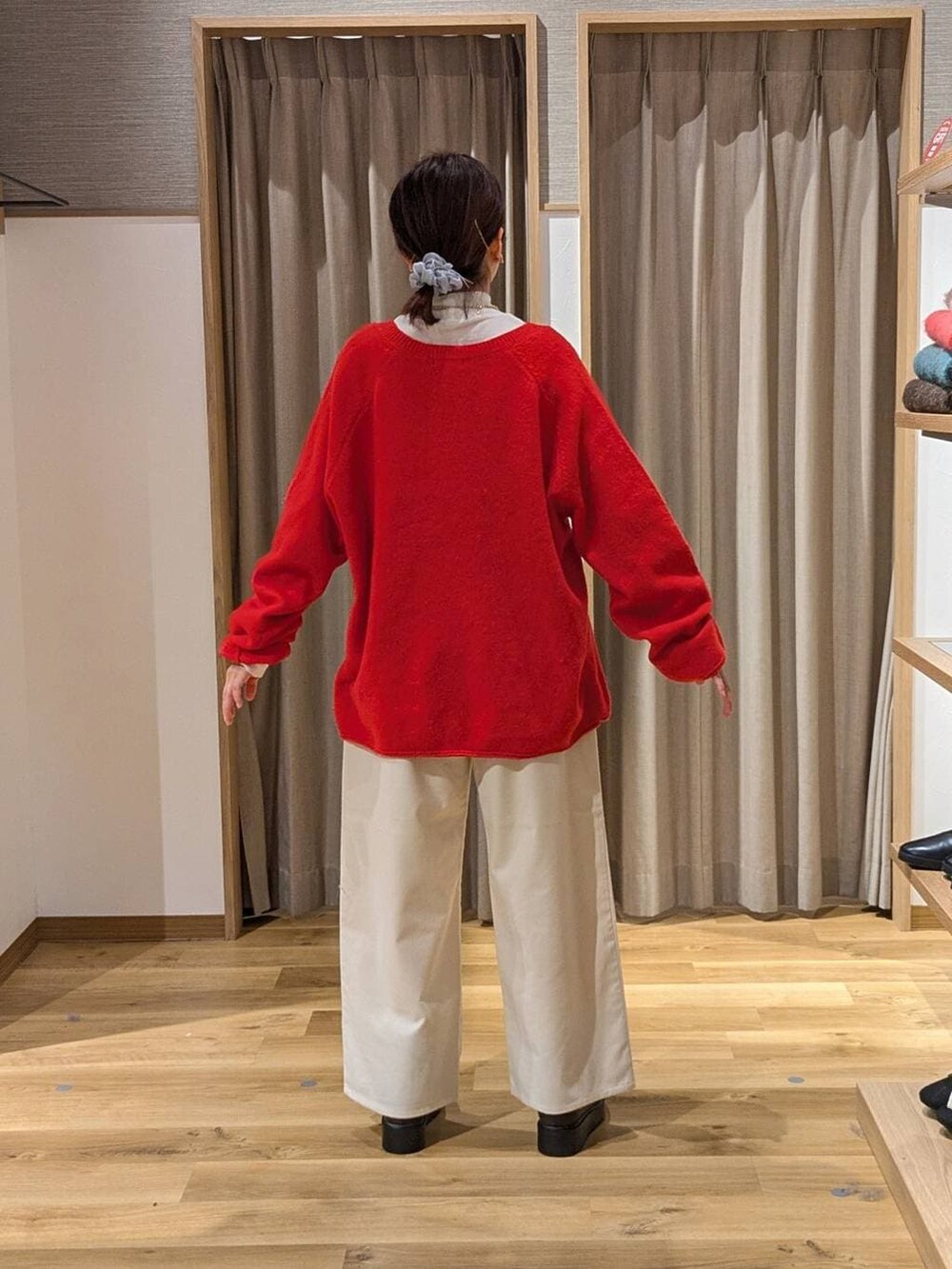 ホワイト系のTシャツ/カットソー、ブラウン系のブーツ、レッド系のニット/セーターを着用したレディースの冬コーディネートの2枚目の写真
