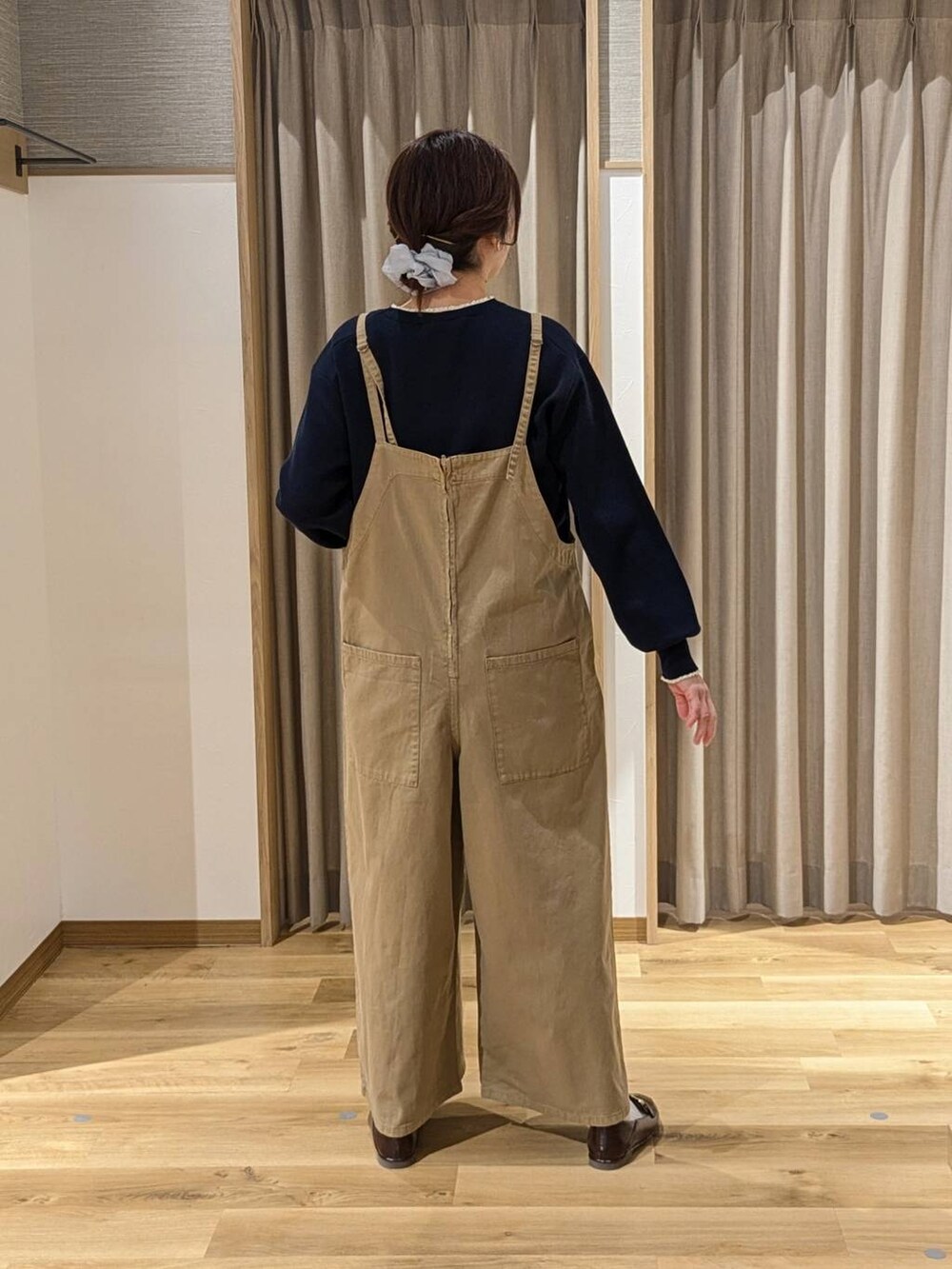 ベージュ系のサロペット/オーバーオール、ブラック系のショルダーバッグ、ブラウン系のローファーを着用したレディースの冬コーディネートの2枚目の写真