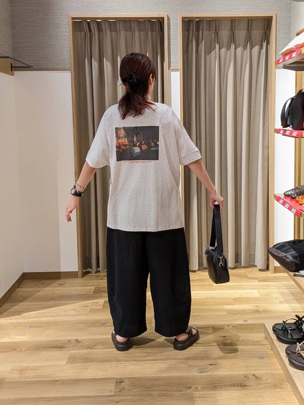 ブラック系のショルダーバッグ、ブラウン系のサンダル、ブラック系のその他パンツを着用したレディースの夏コーディネートの2枚目の写真