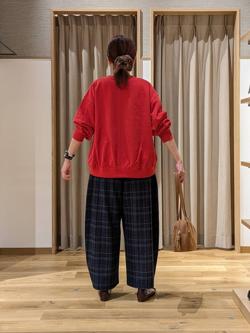 ブラウン系のショルダーバッグ、レッド系のスウェット、ホワイト系のTシャツ/カットソーを着用したレディースの秋コーディネートの3枚目の写真