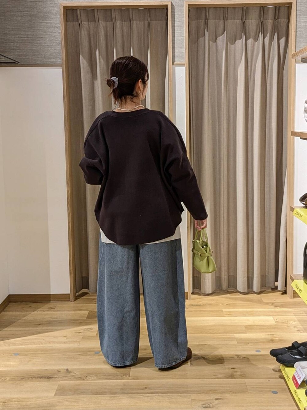 ブルー系のデニムパンツ、グレー系のカーディガン/ボレロ、グリーン系のショルダーバッグを着用したレディースの春コーディネートの2枚目の写真