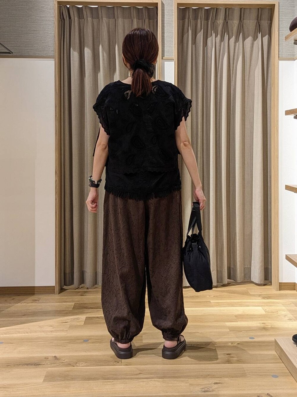 ブラウン系のその他パンツ、ブラック系のシャツ/ブラウス、ブラック系のベストを着用したレディースの夏コーディネートの3枚目の写真