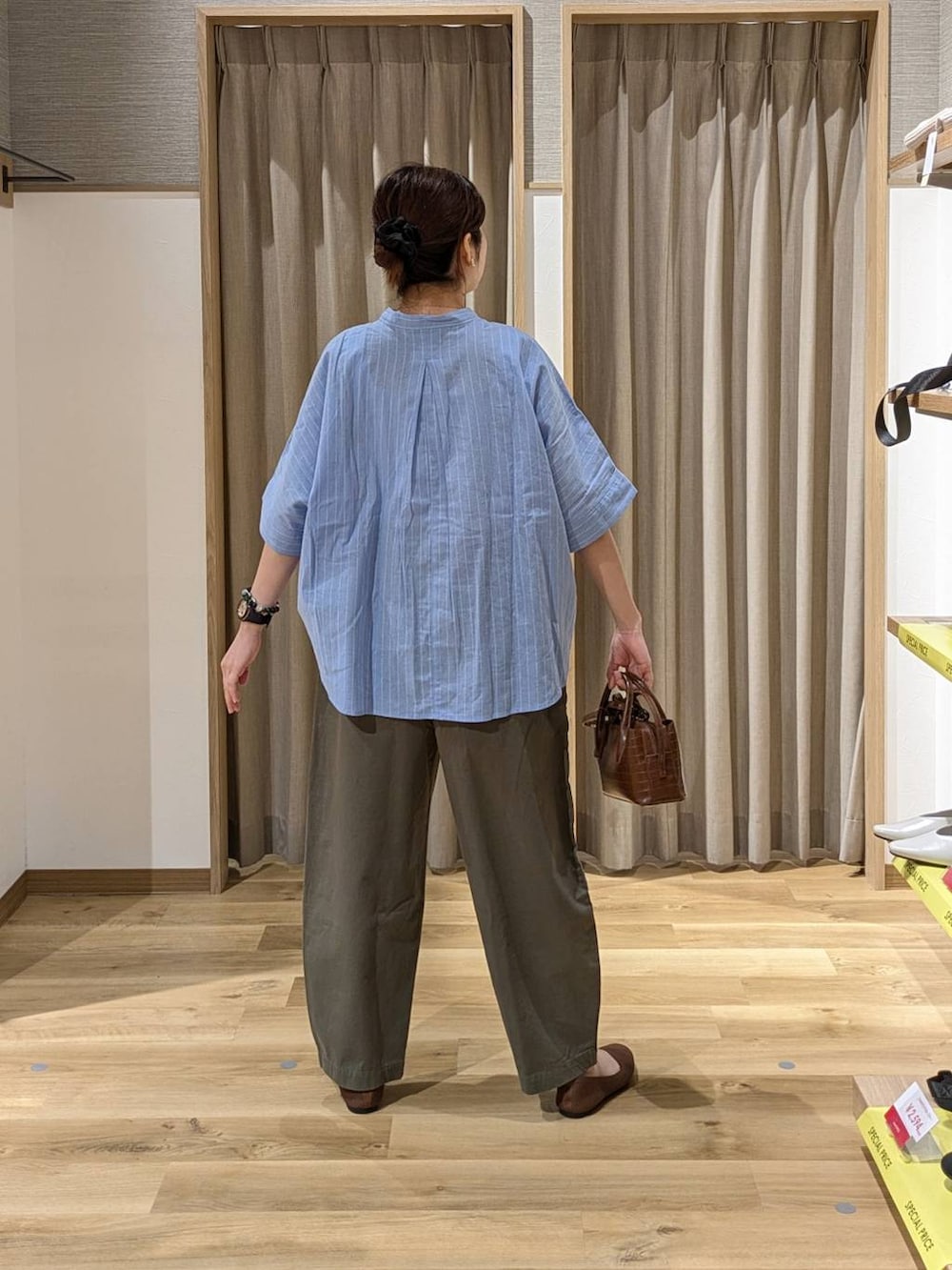 ブラウン系のトートバッグ、グリーン系のその他パンツ、ブラウン系のパンプスを着用したレディースの春コーディネートの2枚目の写真