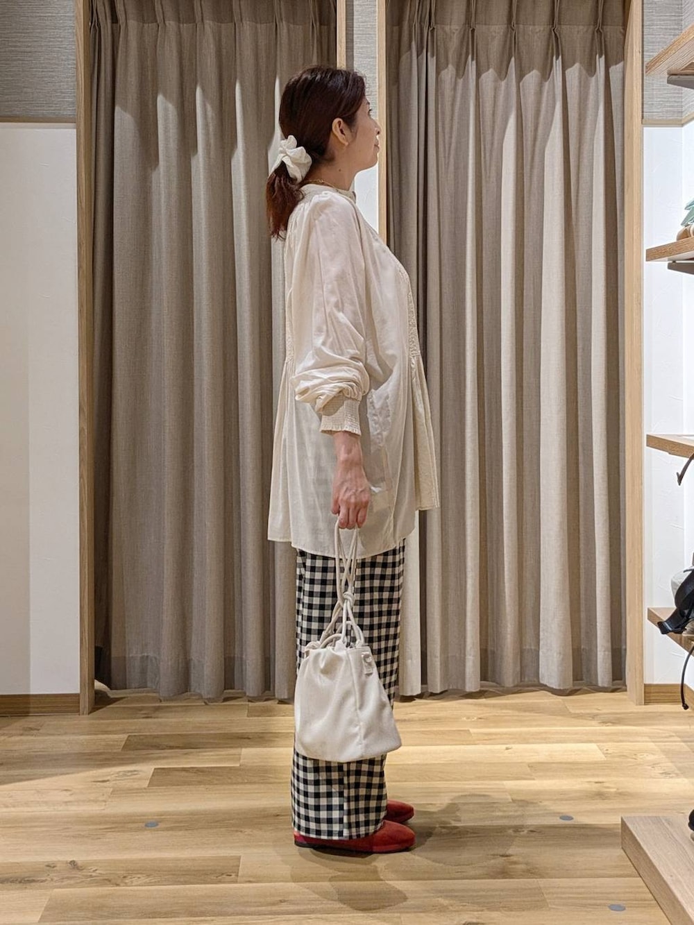 レッド系のその他シューズ、グレー系のショルダーバッグ、ホワイト系のシャツ/ブラウスを着用したレディースの秋コーディネートの2枚目の写真