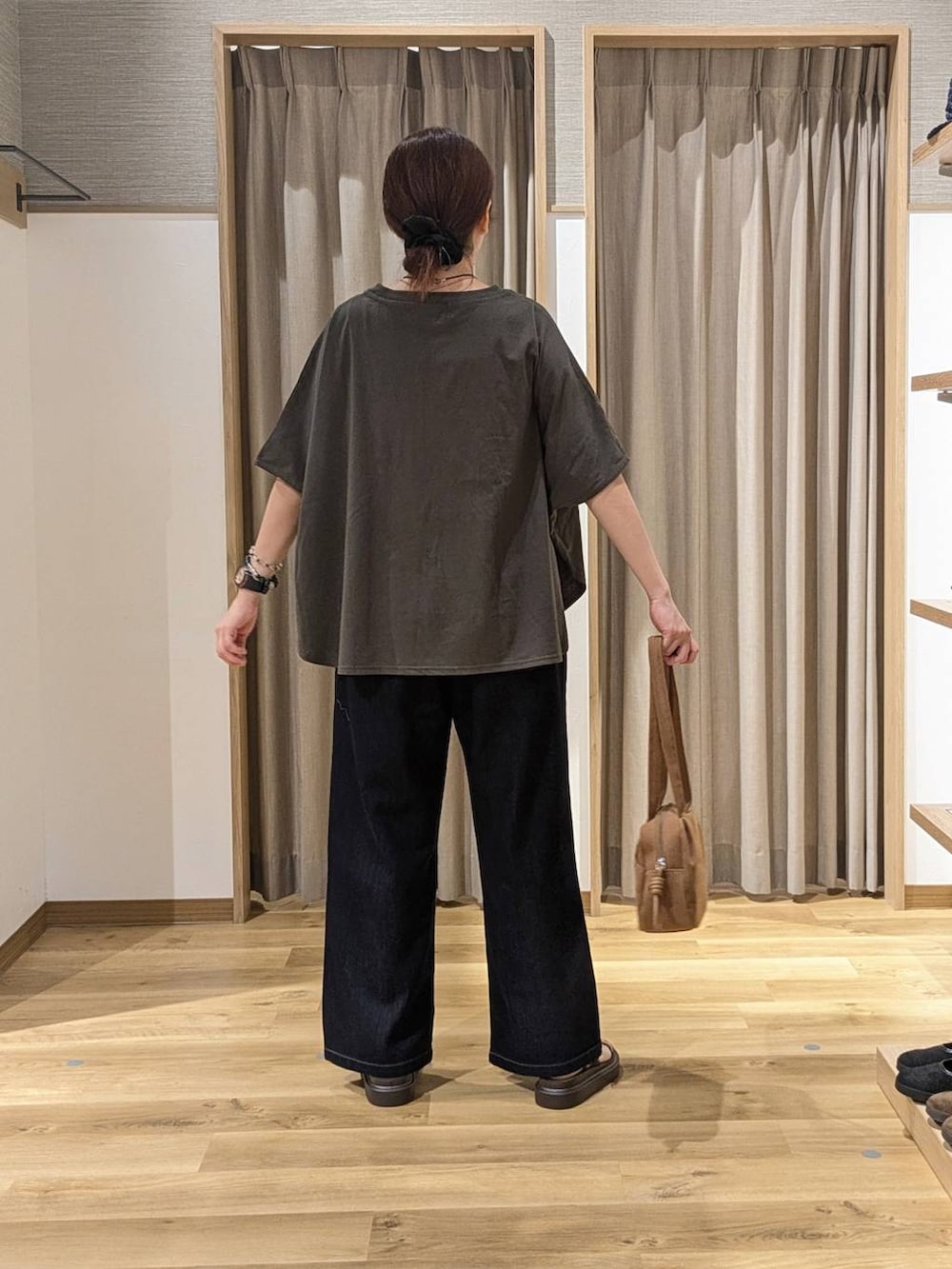 ブラウン系のショルダーバッグ、ブラウン系のサンダル、ブルー系のデニムパンツを着用したレディースの夏コーディネートの3枚目の写真