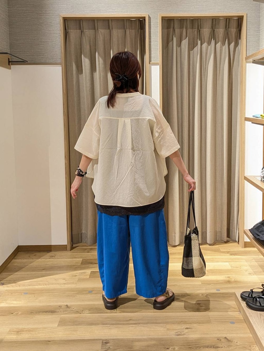 ブラック系のトートバッグ、ベージュ系のサンダル、ブラック系のタンクトップを着用したレディースの夏コーディネートの2枚目の写真
