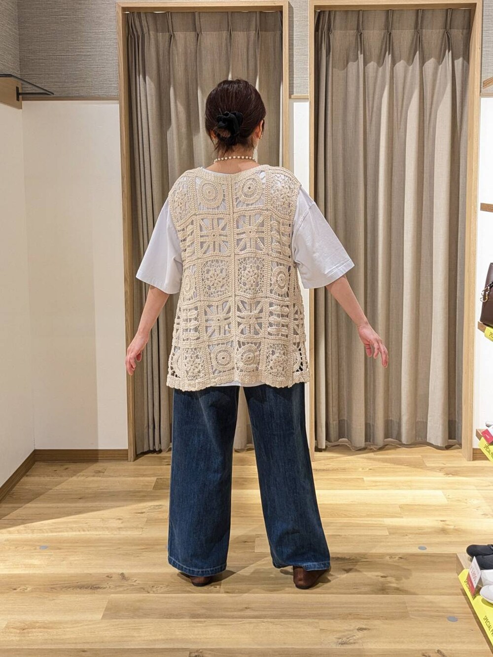 ブラウン系のショルダーバッグ、ブラウン系のパンプス、ベージュ系のベストを着用したレディースの春コーディネートの2枚目の写真