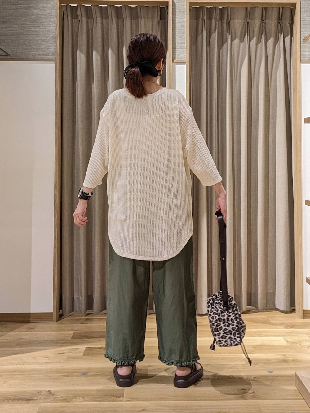 グリーン系のその他パンツ、ベージュ系のTシャツ/カットソー、ブラウン系のサンダルを着用したレディースの夏コーディネートの3枚目の写真