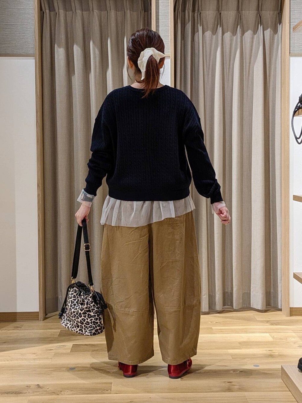 レッド系のその他シューズ、その他のTシャツ/カットソー、ブラウン系のショルダーバッグを着用したレディースの秋コーディネートの3枚目の写真