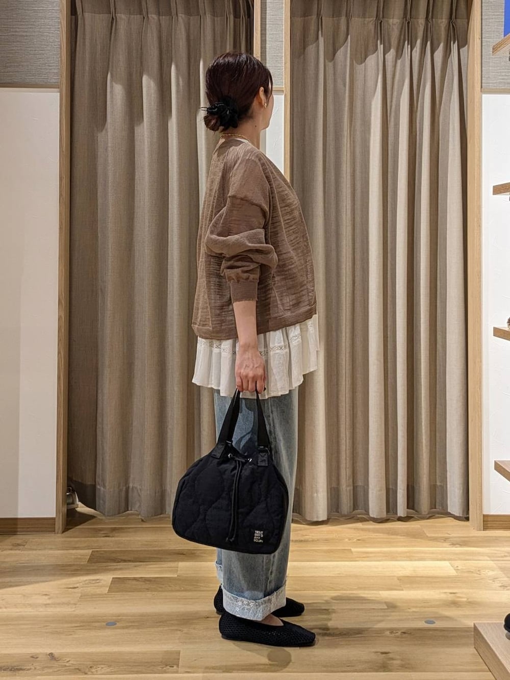 ベージュ系のシャツ/ブラウス、ブルー系のデニムパンツ、ブラック系のパンプスを着用したレディースの秋コーディネートの2枚目の写真