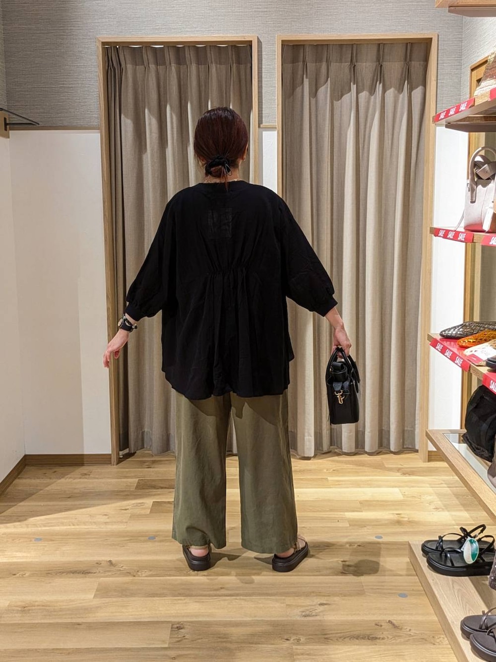 ベージュ系のサンダル、グリーン系のその他パンツ、ブラック系のTシャツ/カットソーを着用したレディースの夏コーディネートの2枚目の写真