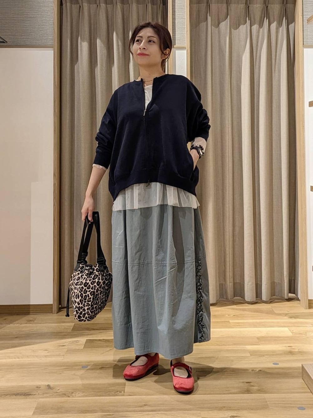 レッド系のその他シューズ、その他のTシャツ/カットソー、ブルー系のスカートを着用したレディースの秋コーディネートの4枚目の写真