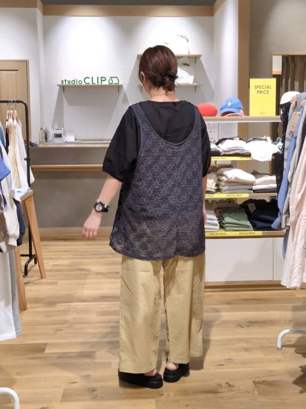 ブラック系のシャツ/ブラウス、ブラック系のサンダル、グレー系のベストを着用したレディースの春コーディネートの2枚目の写真