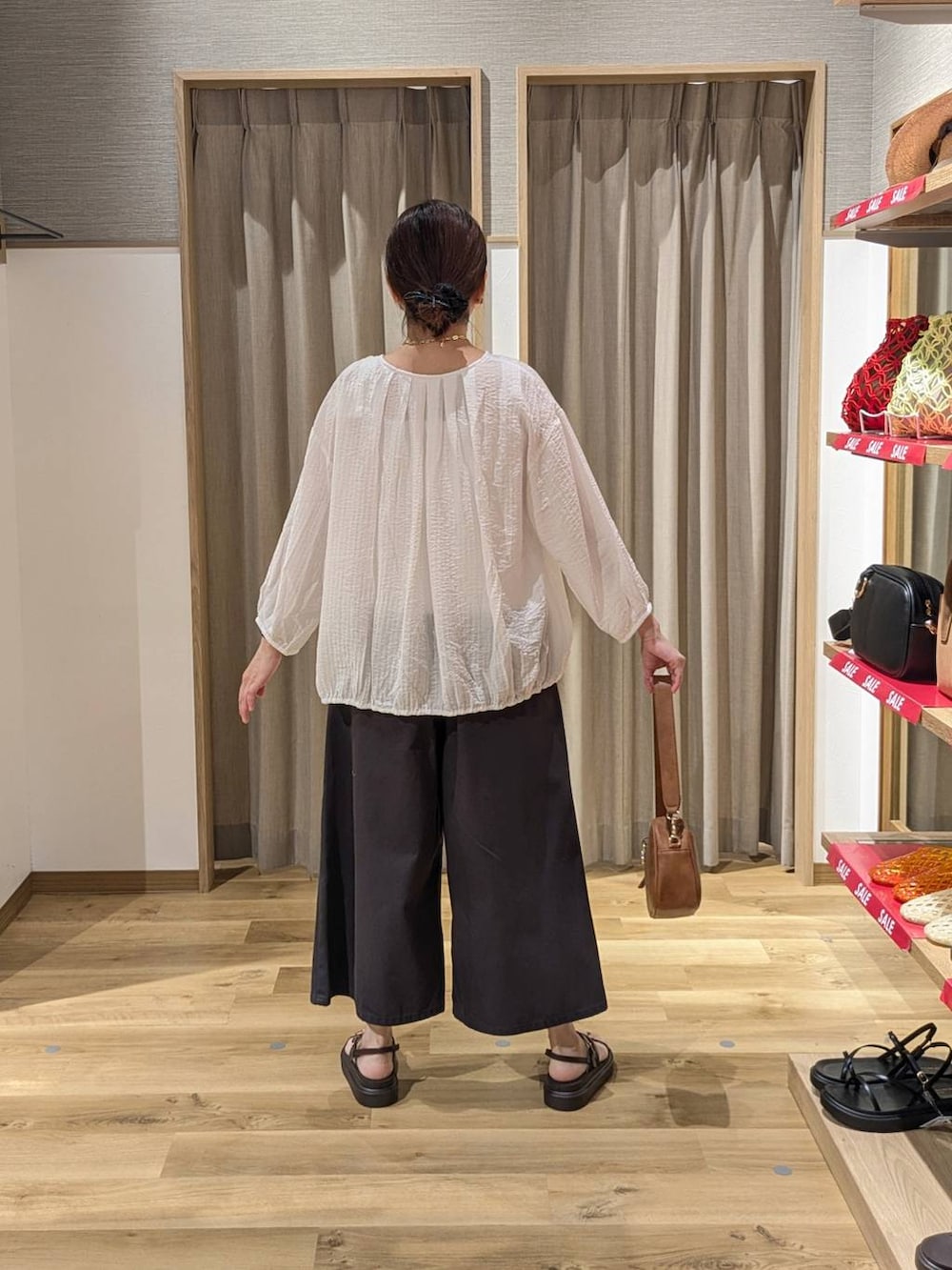 ブラウン系のショルダーバッグ、ブラック系のサンダル、ベージュ系のタンクトップを着用したレディースの夏コーディネートの2枚目の写真