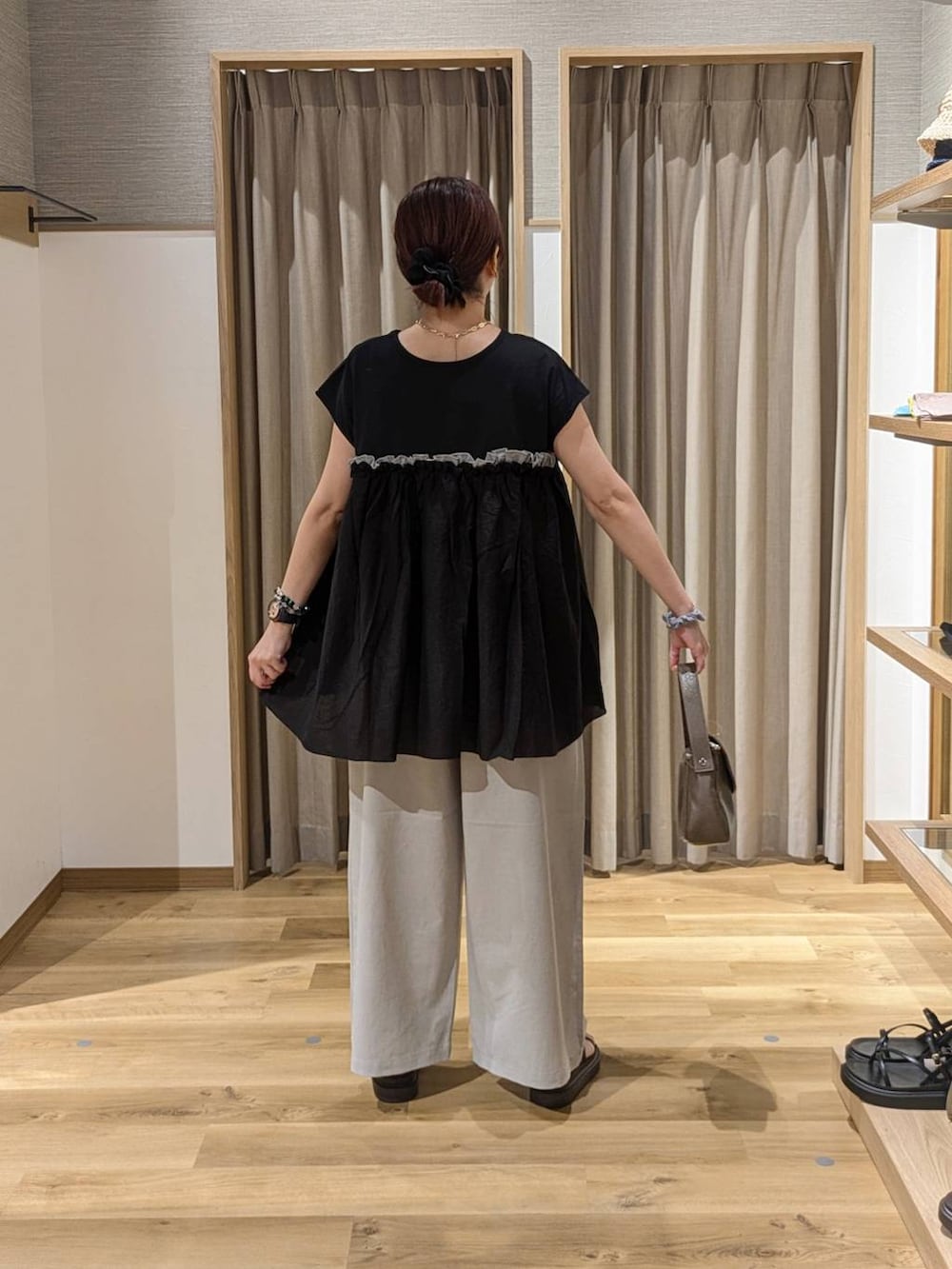 ブラウン系のサンダル、グレー系のその他パンツ、ブラウン系のショルダーバッグを着用したレディースの夏コーディネートの2枚目の写真