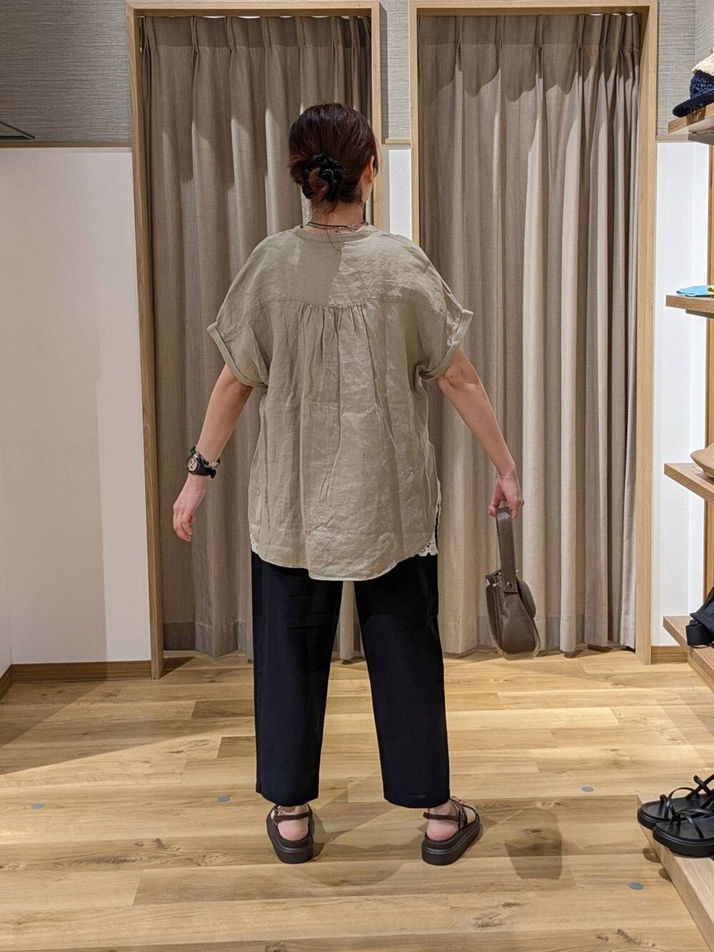 ブラウン系のサンダル、ブルー系のその他パンツ、ブラウン系のショルダーバッグを着用したレディースの夏コーディネートの2枚目の写真