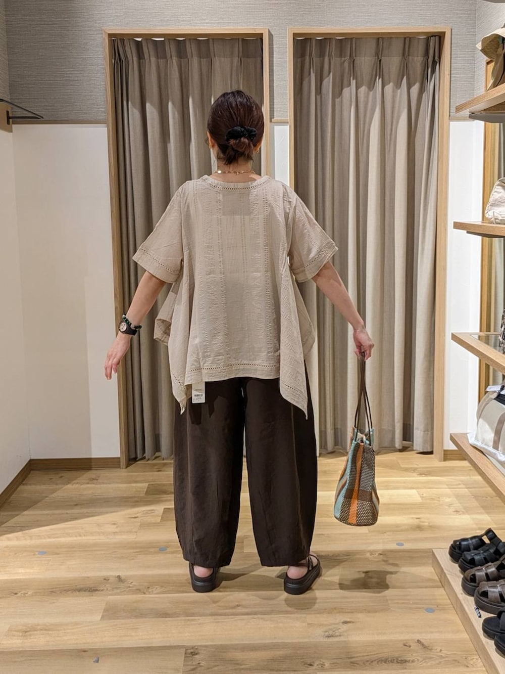 ブラウン系のトートバッグ、ブラウン系のサンダル、ブラウン系のその他パンツを着用したレディースの夏コーディネートの2枚目の写真