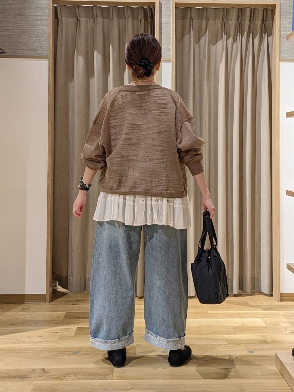 ベージュ系のシャツ/ブラウス、ブルー系のデニムパンツ、ブラック系のパンプスを着用したレディースの秋コーディネートの3枚目の写真