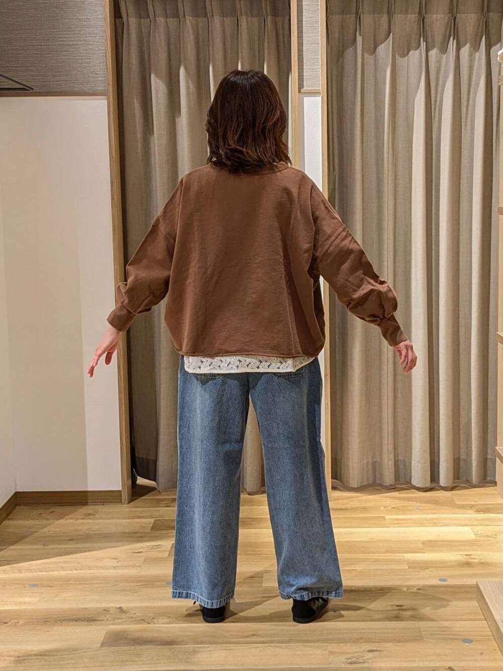 ホワイト系のTシャツ/カットソー、ブルー系のデニムパンツ、ブラック系のスニーカーを着用したレディースの冬コーディネートの2枚目の写真