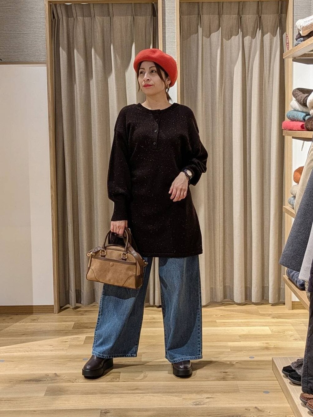 ブルー系のデニムパンツ、ブラウン系のブーツ、ブラウン系のショルダーバッグを着用したレディースの冬コーディネートの2枚目の写真