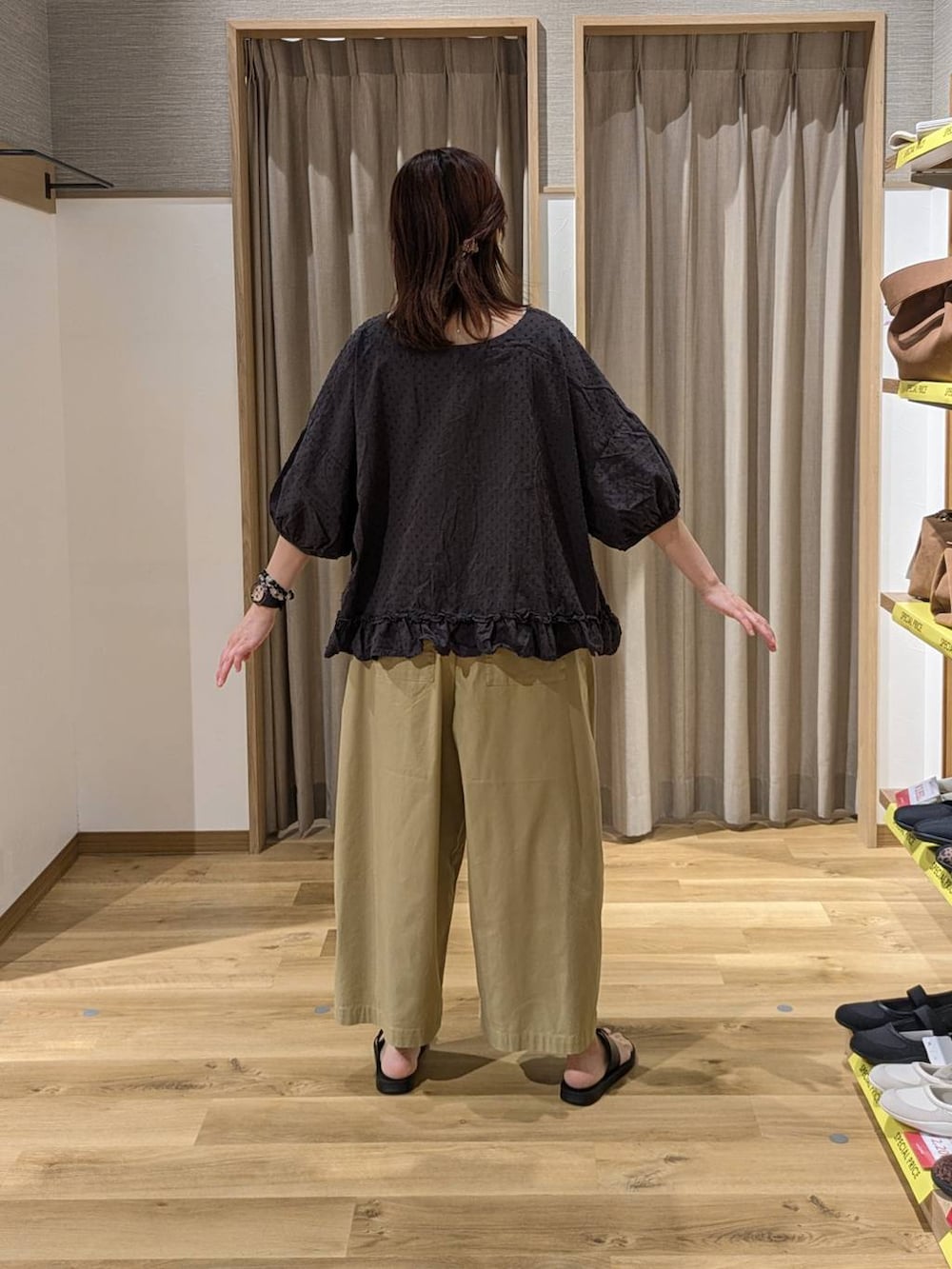 ベージュ系のトートバッグ、ベージュ系のその他パンツ、ブラック系のサンダルを着用したレディースの春コーディネートの2枚目の写真