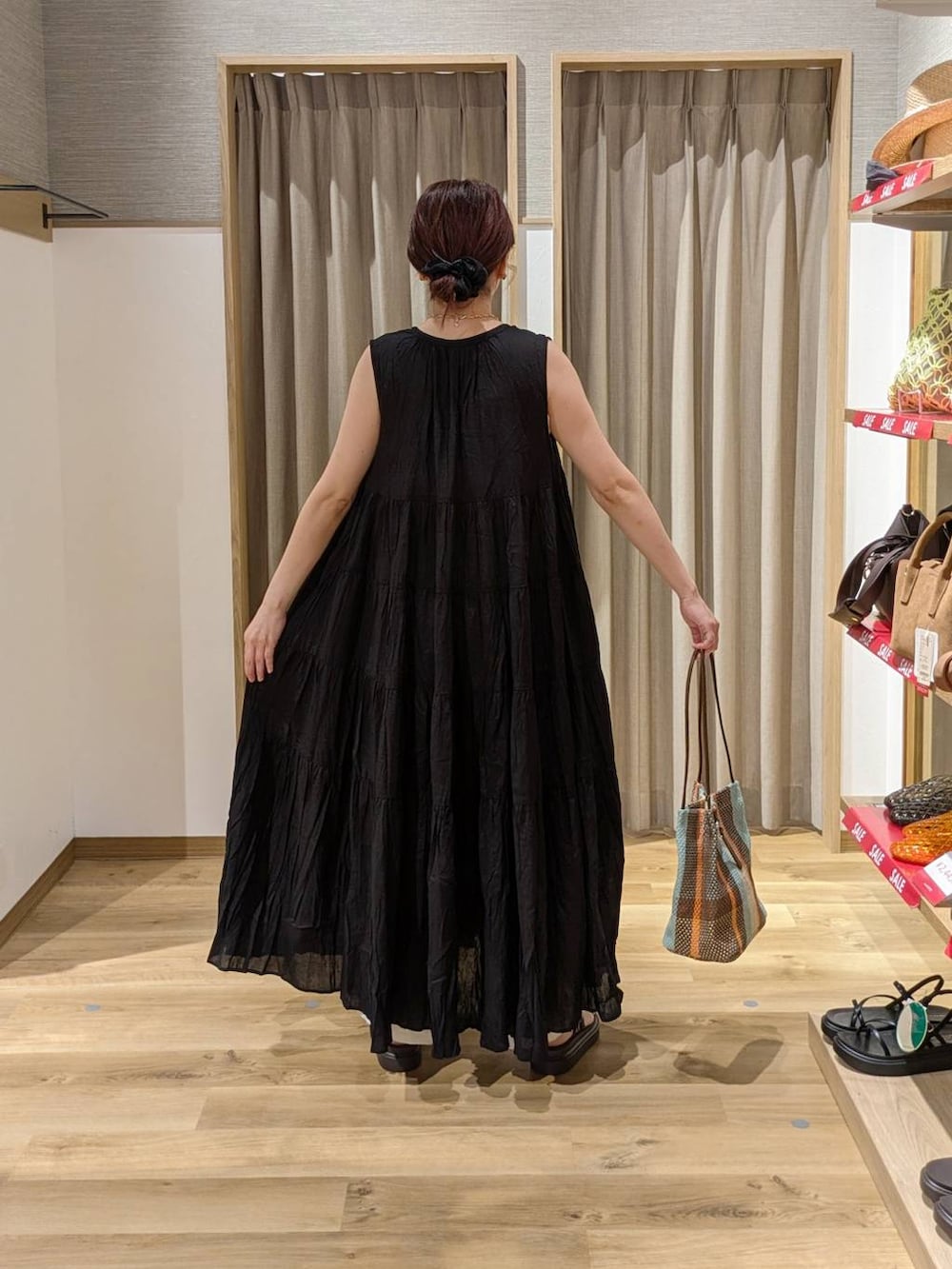 ベージュ系のその他パンツ、ブラウン系のトートバッグ、ブラウン系のサンダルを着用したレディースの夏コーディネートの2枚目の写真
