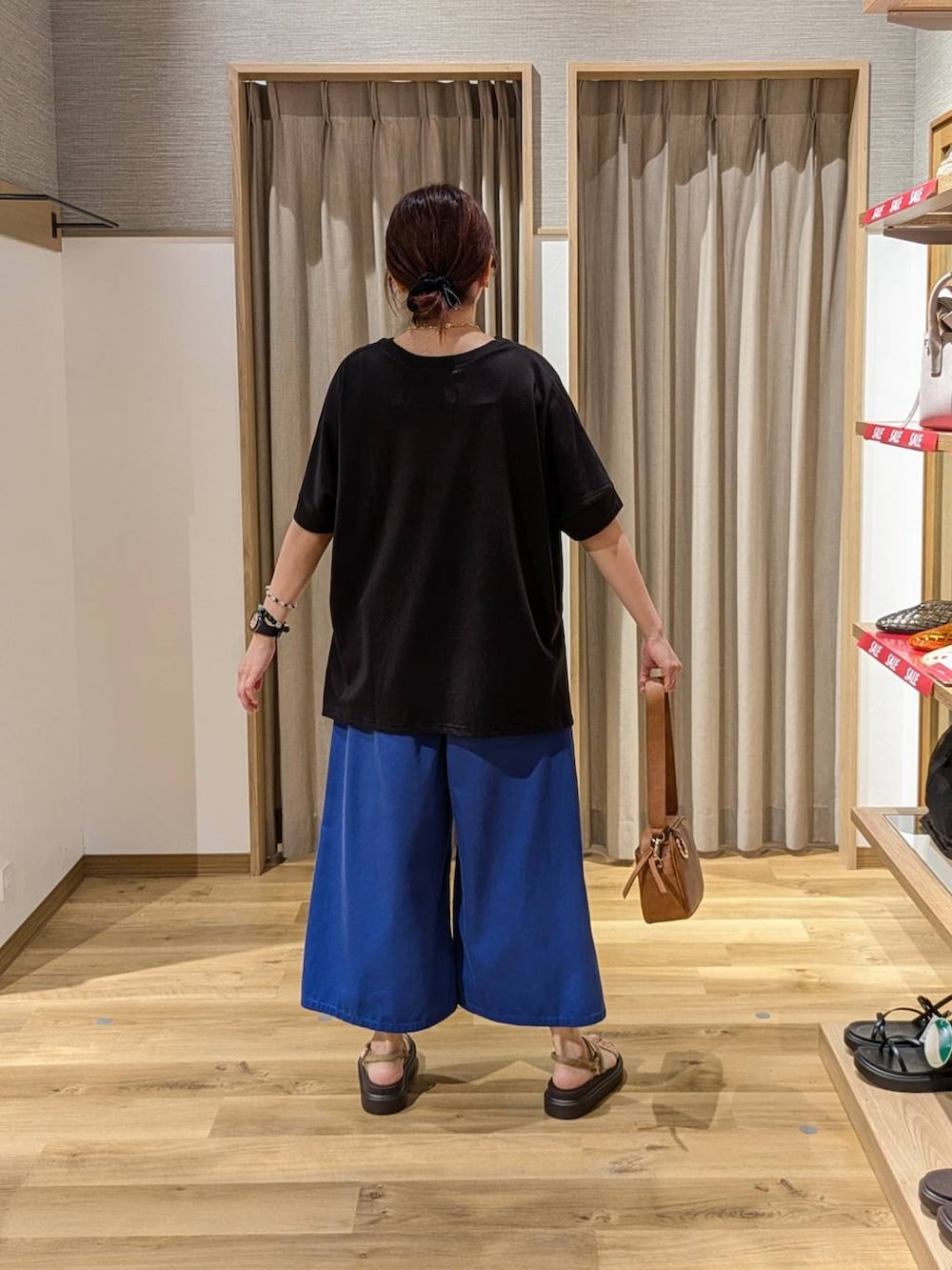 ブラウン系のショルダーバッグ、ベージュ系のサンダル、ブルー系のその他パンツを着用したレディースの夏コーディネートの2枚目の写真