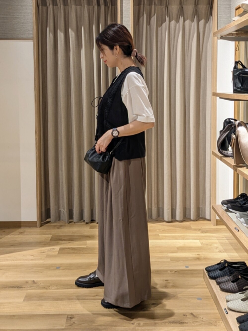 ブラック系のショルダーバッグ、ホワイト系のTシャツ/カットソー、ブラウン系のローファーを着用したレディースの秋コーディネートの2枚目の写真