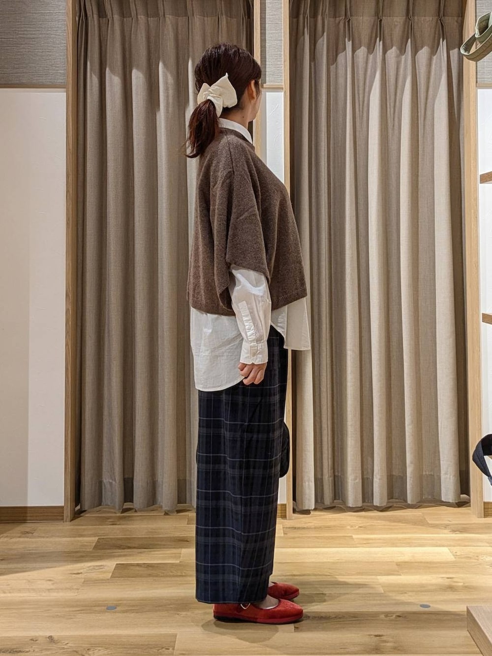 レッド系のその他シューズ、ブラウン系のベスト、ブラック系のその他パンツを着用したレディースの秋コーディネートの2枚目の写真