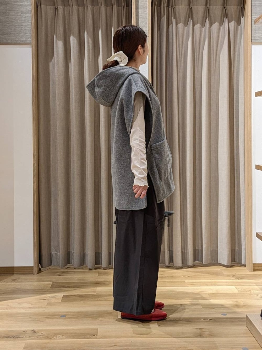 レッド系のその他シューズ、グレー系のその他アウター、ブラック系のショルダーバッグを着用したレディースの秋コーディネートの2枚目の写真