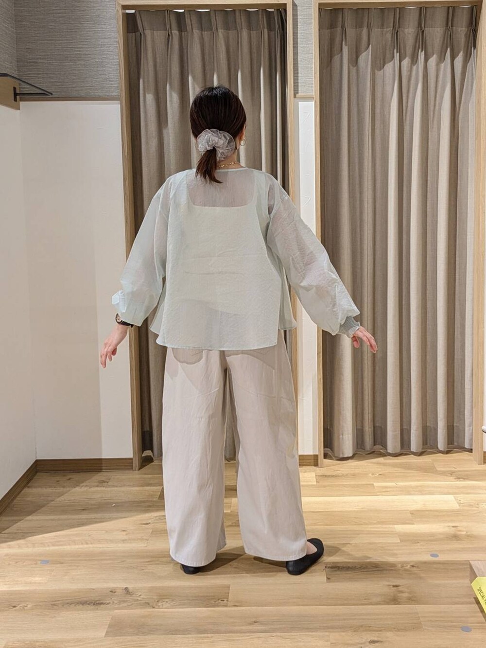 ブラック系のトートバッグ、グレー系のパンプス、ベージュ系のタンクトップを着用したレディースの春コーディネートの2枚目の写真