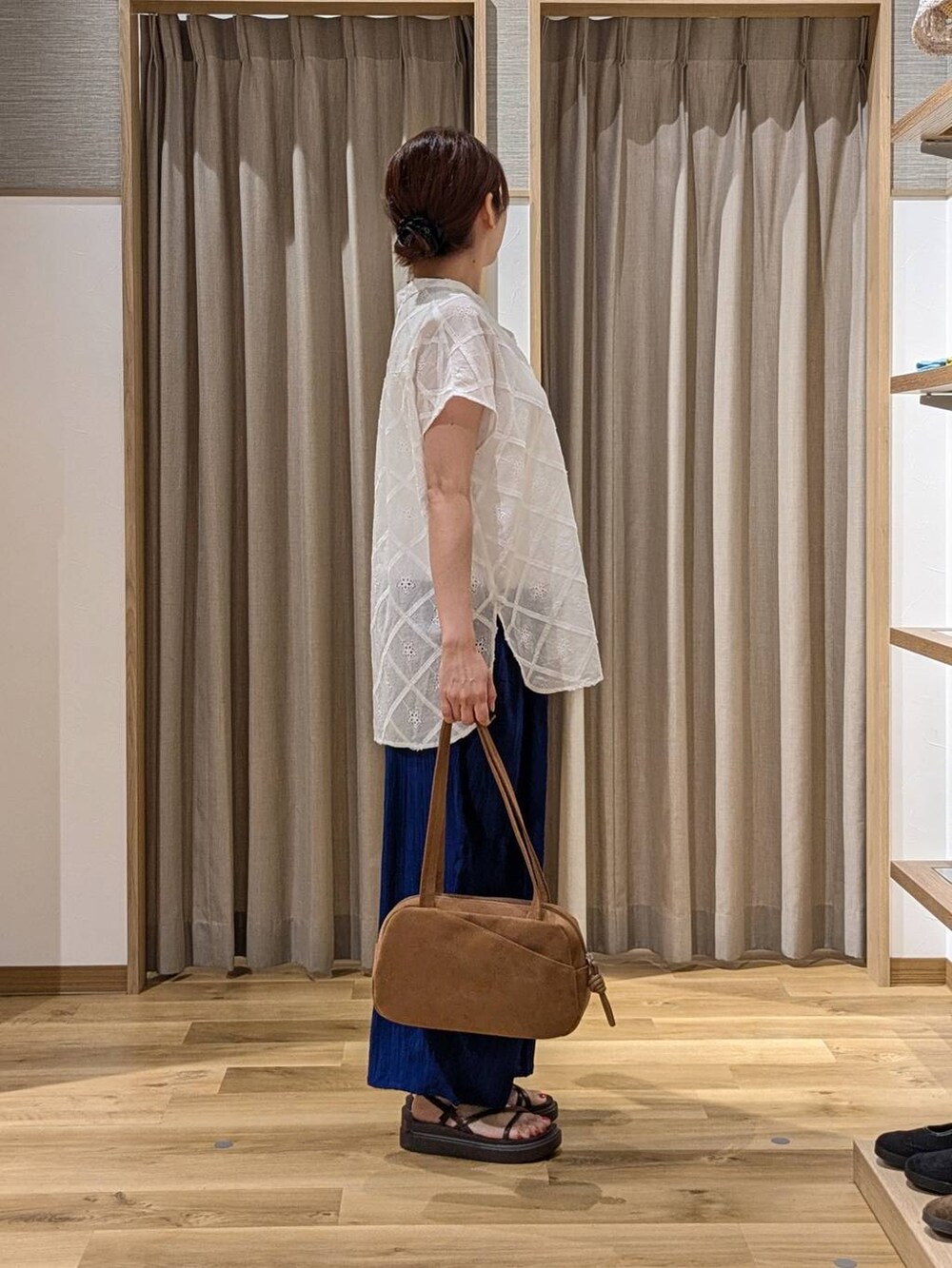 ブラウン系のショルダーバッグ、ブルー系のその他パンツ、ブラウン系のサンダルを着用したレディースの夏コーディネートの2枚目の写真