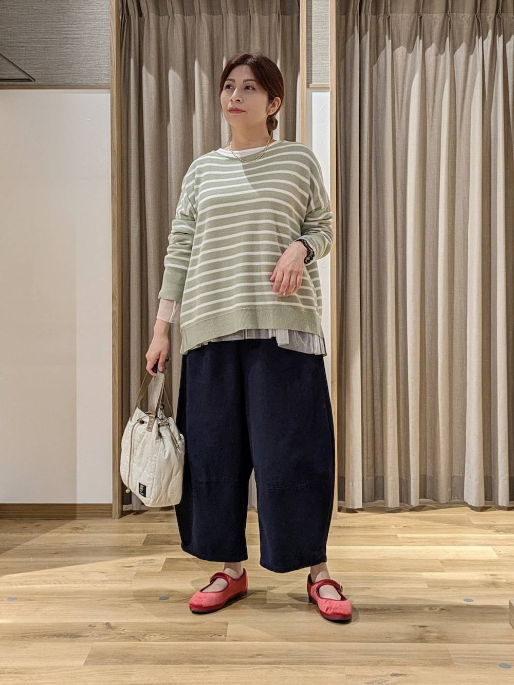 レッド系のその他シューズ、その他のTシャツ/カットソー、グリーン系のニット/セーターを着用したレディースの秋コーディネートの4枚目の写真