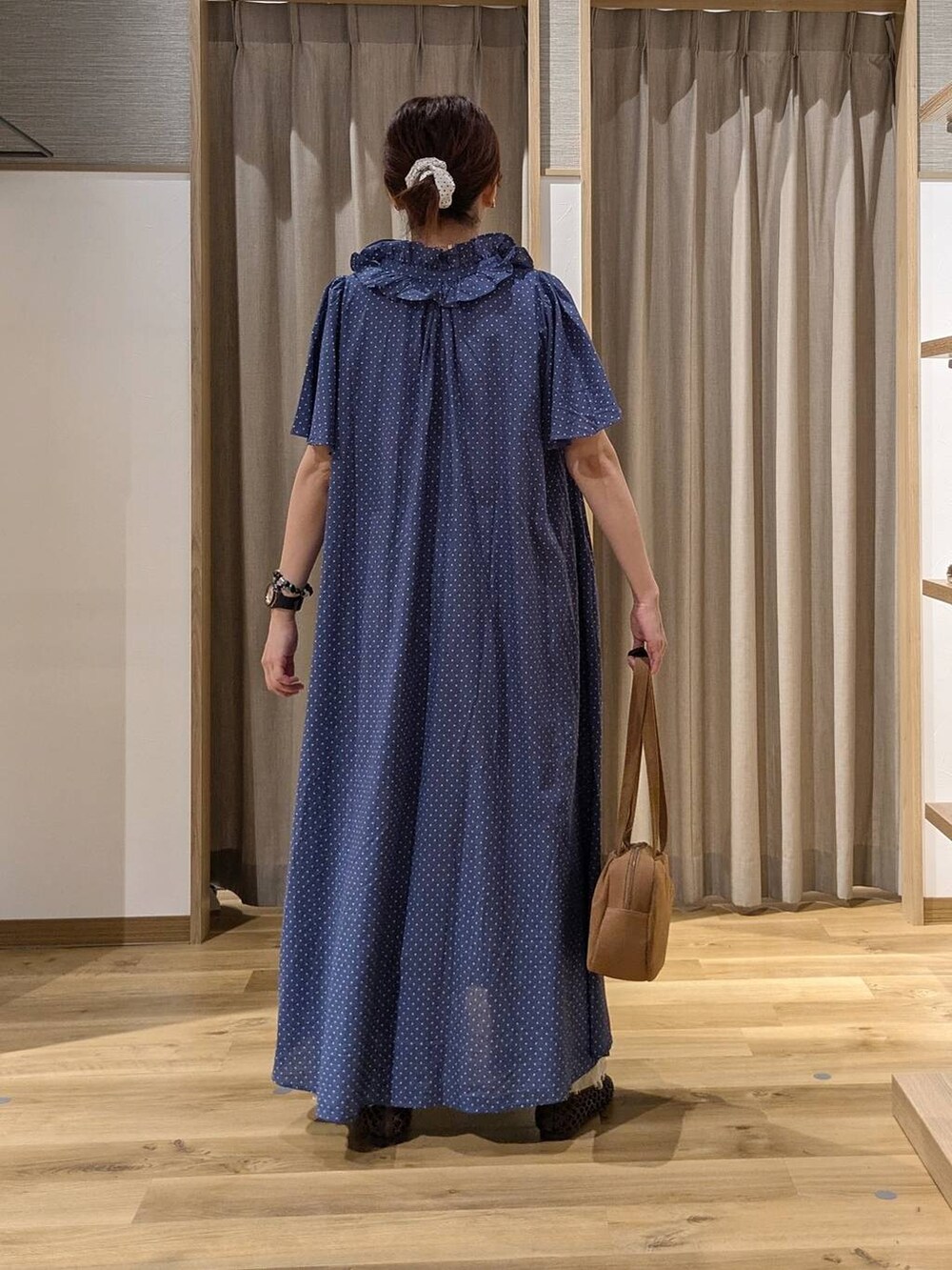 ブラウン系のショルダーバッグ、ベージュ系のデニムパンツ、ブラウン系のパンプスを着用したレディースの秋コーディネートの4枚目の写真