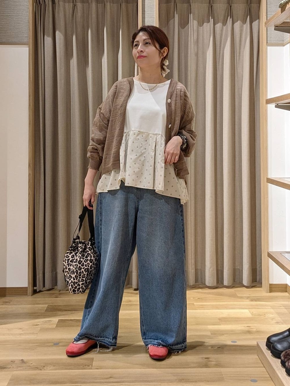 レッド系のその他シューズ、ベージュ系のTシャツ/カットソー、ブルー系のデニムパンツを着用したレディースの秋コーディネートの3枚目の写真